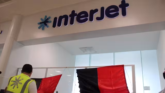 Empleados de la aerolínea Interjet colocan en estos momentos las banderas rojinegras para anunciar el inicio de la huelga