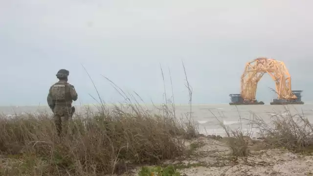 Un elemento de la Semar observa la estructura entre el mar picado
