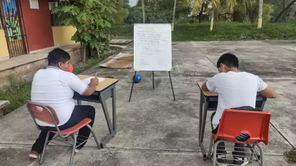 Los estudiantes salen a la plaza civica a realizar sus tareas debido a la falta de luz y exceso de calor Los estudiantes salen a la plaza civica a realizar sus tareas debido a la falta de luz y exceso de calor