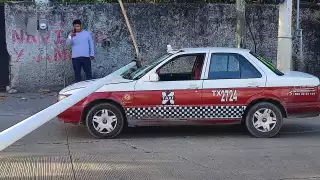 Después de derribar el poste, este cayó sobre un taxi