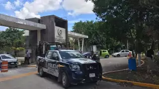 Elementos de la Policía mantuvieron la vigilancia en la entrada de Privadas Turquesa en Cancún durante el operativo en una vivienda de la zona