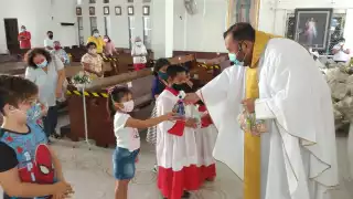 El cura católico regaló dulces a los infantes por su día