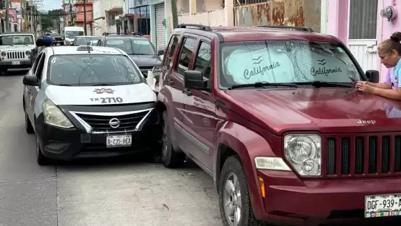 Un taxi Nissan Versa chocó contra una camioneta estacionada en la colonia Guanal.