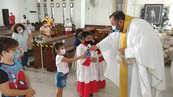 El cura católico regaló dulces a los infantes por su día El cura católico regaló dulces a los infantes por su día
