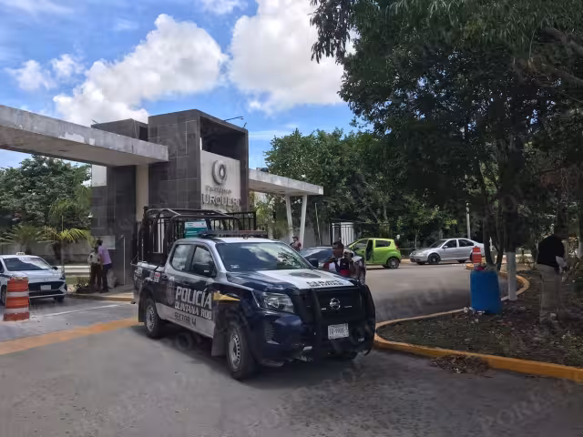 Elementos de la Policía mantuvieron la vigilancia en la entrada de Privadas Turquesa en Cancún durante el operativo en una vivienda de la zona