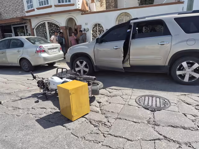 Una pareja de motociclistas se impactó contra la puerta de una GMC Acadia.