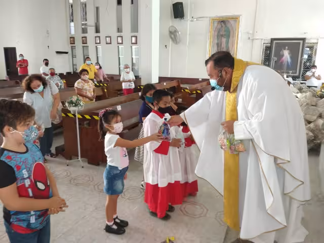 El cura católico regaló dulces a los infantes por su día
