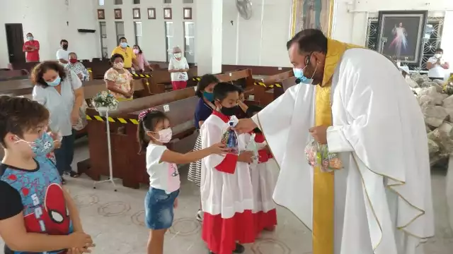 El cura católico regaló dulces a los infantes por su día