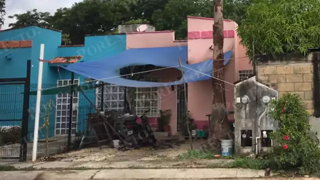 La motocicleta incendiada quedó en el patio frontal de la casa rafagueada en la zona urbana de Cancún