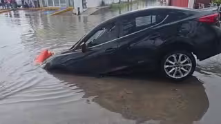 Auto cae en zanja de la CFE oculta por inundación en Chetumal; conductor sale ileso
