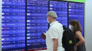 Los viajeros esperan poder abordar un avión a su lugar de origen