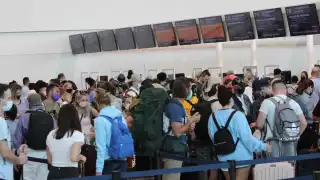 Los pasajeros de los vuelos cancelados a Estados Unidos y a Chile, se acercaron a los módulos de sus aerolíneas en el aeropuerto de Cancún para ver su situación