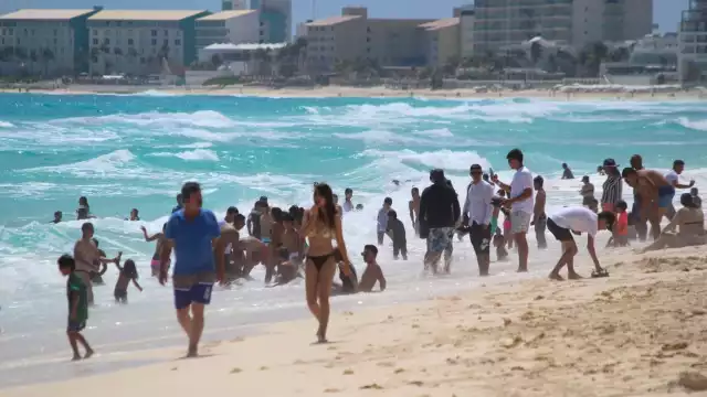 Los visitantes hacen largas colas para tomarse fotos en las letras de Cancún en Playa Delfines