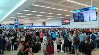 Los pasajeros hicieron largas filas para documentar su equipaje en el Aeropuerto Internacional de Cancún