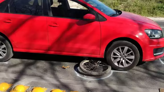 Ante el accidente, vecinos ayudaron a levantar el carro para poder sacar al ciclista Ante el accidente, vecinos ayudaron a levantar el carro para poder sacar al ciclista