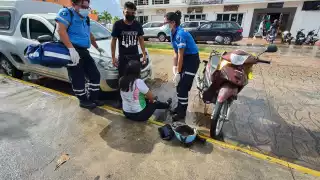Motociclista derrapa sobre carretera mojada en avenida Rafael E. Melgar en Playa del Carmen