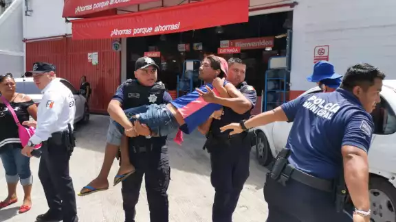 Una mujer intentó detener a los policías para evitar que detuvieran al joven, quien fue cargado hacia la patrulla Una mujer intentó detener a los policías para evitar que detuvieran al joven, quien fue cargado hacia la patrulla