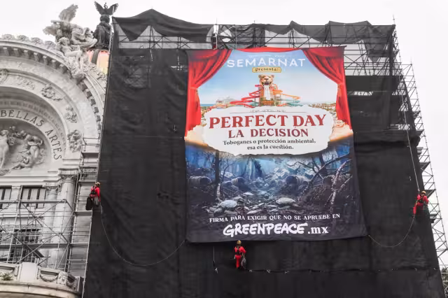 Varias personas vestidas con prendas rojas subieron a los andamios para colocar el mensaje