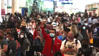 Algunos de los viajeros se les observa sentados en el piso, esperando poder pasar al aérea de check in
