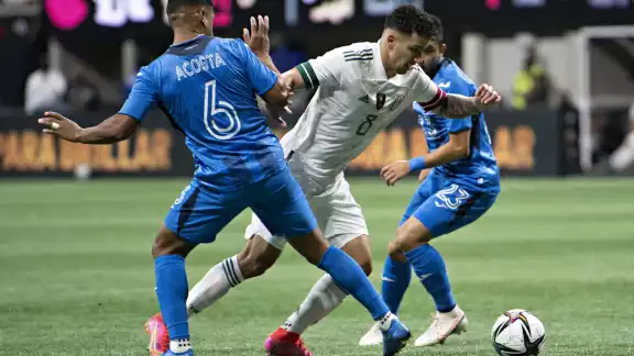 Dos jugadores de Honduras intentan robarle el esférico a un mexicano Dos jugadores de Honduras intentan robarle el esférico a un mexicano