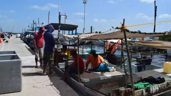 Pescadores alistan sus naves para salir a la mar tras varios días de permanecer en el puerto de embarque en Progreso