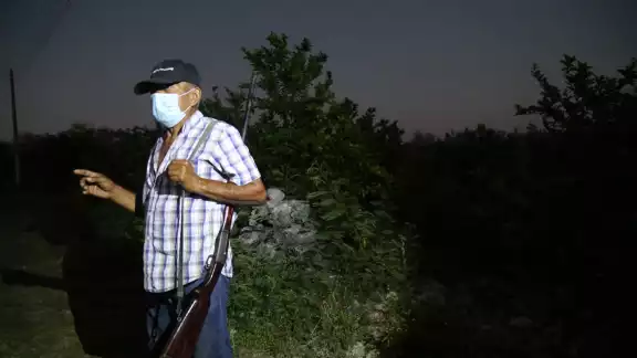 Jorge, con su rifle al hombro, camina las veredas del paraje para esperar a los ladrones Jorge, con su rifle al hombro, camina las veredas del paraje para esperar a los ladrones