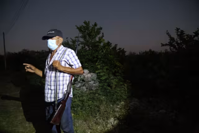 Jorge, con su rifle al hombro, camina las veredas del paraje para esperar a los ladrones