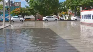 Más de una docena de baches se encuentran abajo del agua en esta calle inundada