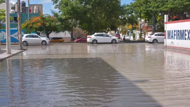 Más de una docena de baches se encuentran abajo del agua en esta calle inundada