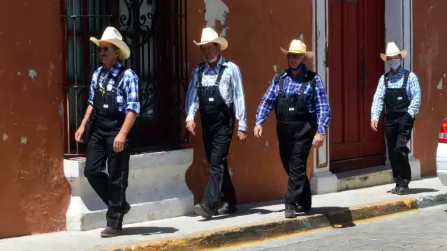 Menonitas ataviados en overoles y camisas a cuadros