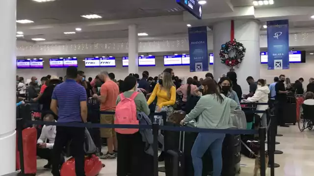 Los turistas hicieron largas filas para hacer su check-in en el aeropuerto de Cancún