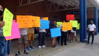 Los manifestantes exigieronmejores condiciones laborales y el pago de un bono afuera de las tiendas Walmart y Sam's Club en Cancún