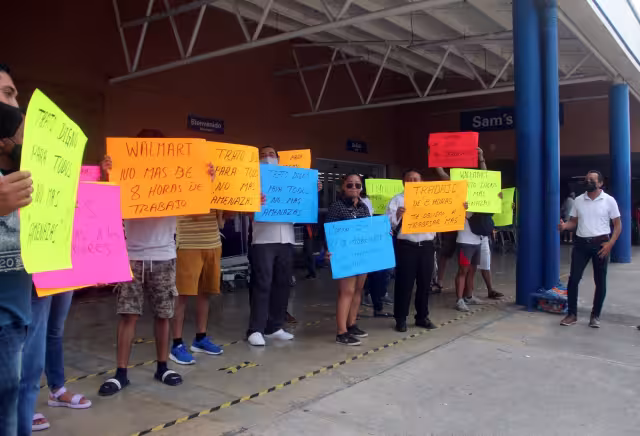 Los manifestantes exigieronmejores condiciones laborales y el pago de un bono afuera de las tiendas Walmart y Sam's Club en Cancún