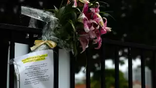 Alrededor de las fotos hay ramos de flores y se colocaron velas en el suelo