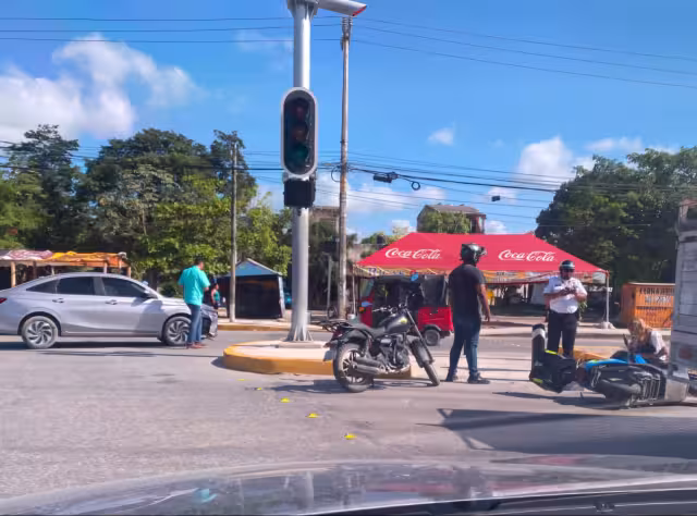La motociclista cayó sobre el pavimento y fue auxiliada por algunos conductores.