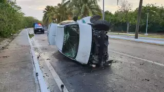 El taxi quedó volcado sobre su lado derecho en la Zona Hotelera de Cancún, hasta la llegada de una grúa, que luego lo remolcó fuera de la vía