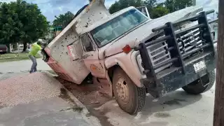 La grava que transportaba el volquete se regó en la acera