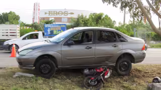 La motocicleta quedó debajo del auto, mientras que su conductor logró saltar antes de ser atropellado