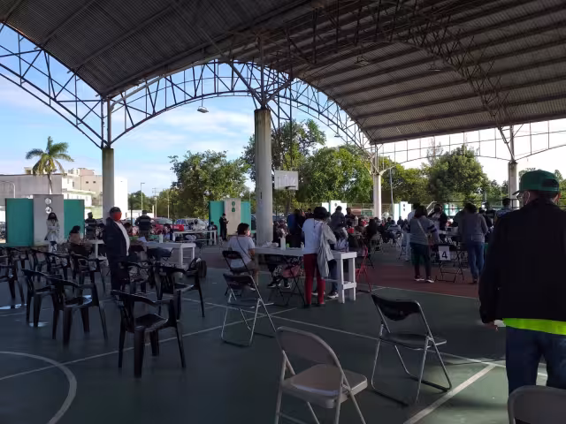 Los maestros que han acudido a vacunarse esperan en filas con sus documentos para registrarse y les apliquen la vacuna