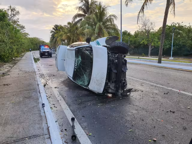 El taxi quedó volcado sobre su lado derecho en la Zona Hotelera de Cancún, hasta la llegada de una grúa, que luego lo remolcó fuera de la vía