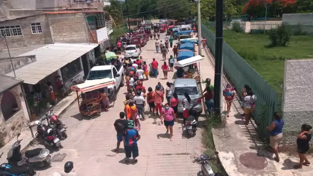 Una larga fila se forma afuera de la escuela normal de personas que fueron por su pedazo de carne robada