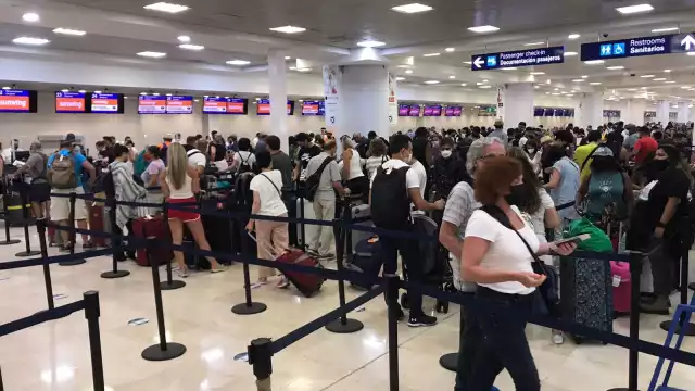 Los pasajeros en el aeropuerto de Cancún hacen filas para documentar su equipaje o preguntar a qué hora saldrá su vuelo, en caso de que tuvieise atrasos