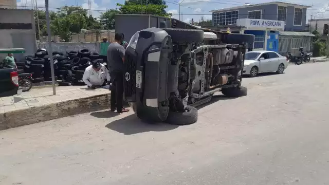 Una camioneta Nissan blanca se volcó debido al exceso de peso de su carga de llantas.
