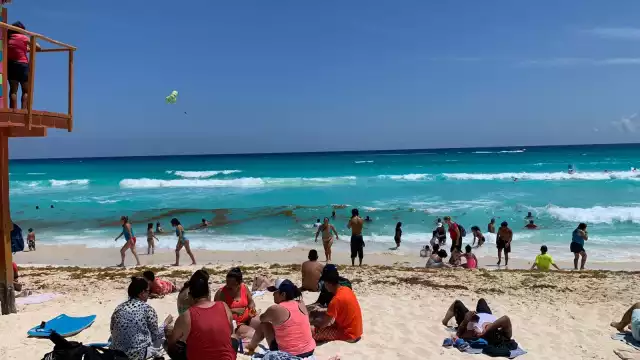 Familias enteras disfrutan del agua color turquesa de la playa