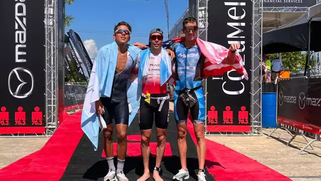 Los atletas que ocuparon los tres primeros lugares del Ironman de Cozumel se fotografiaron con sus respectivas banderas