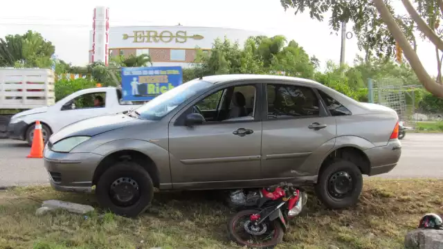 La motocicleta quedó debajo del auto, mientras que su conductor logró saltar antes de ser atropellado