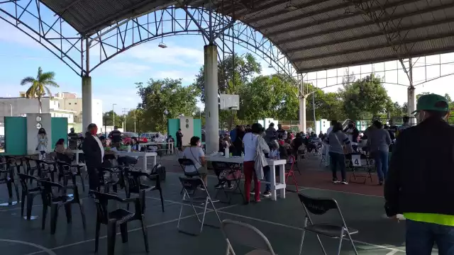 Los maestros que han acudido a vacunarse esperan en filas con sus documentos para registrarse y les apliquen la vacuna