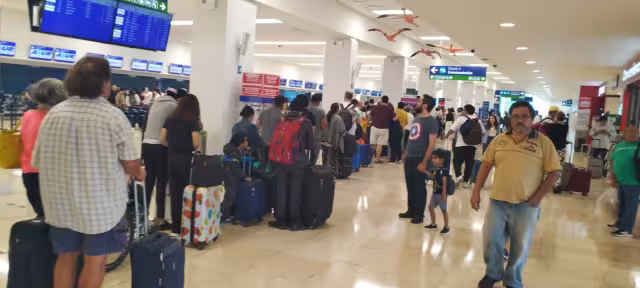 Pasajeros esperan en abordar sus vuelos