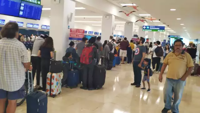 Pasajeros esperan en abordar sus vuelos