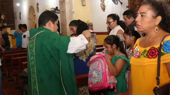 El sacerdote bendijo mochilas y útiles escolares de los niños y jóvenes El sacerdote bendijo mochilas y útiles escolares de los niños y jóvenes